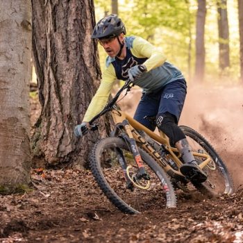 Man riding bike trail through forest