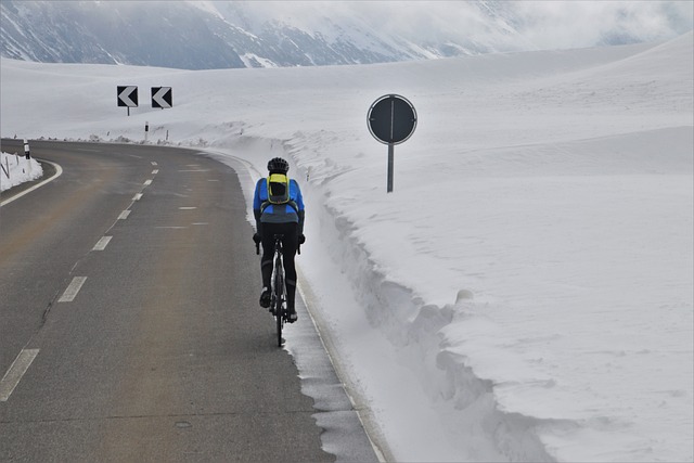 Person riding bike along road during winter