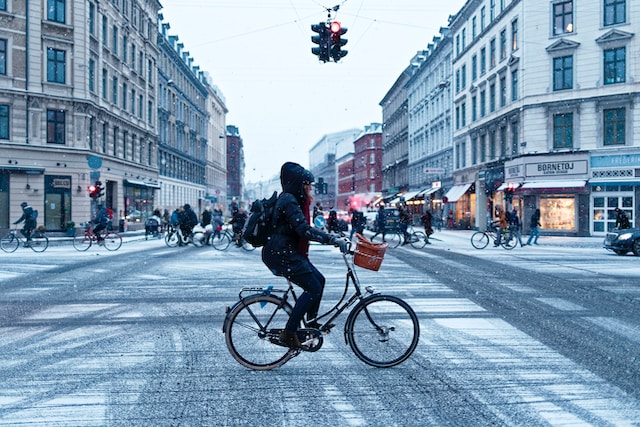 Person riding bike through busy city in winter