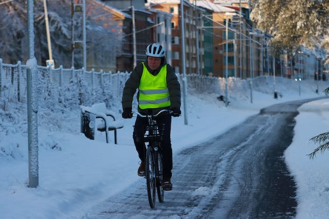 Person riding bike along path during winter