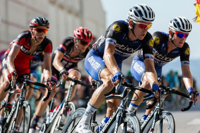 Cyclists take a corner in an intense race.