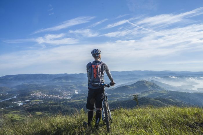 A cyclist admiring a view of mountains.